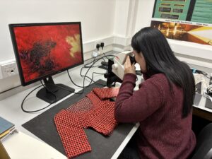 Prize Papers Project Conservator Marina Casagrande carrying out microscopic analysis of the fibres in the Faroese sweater. Photo credit: The National Archives